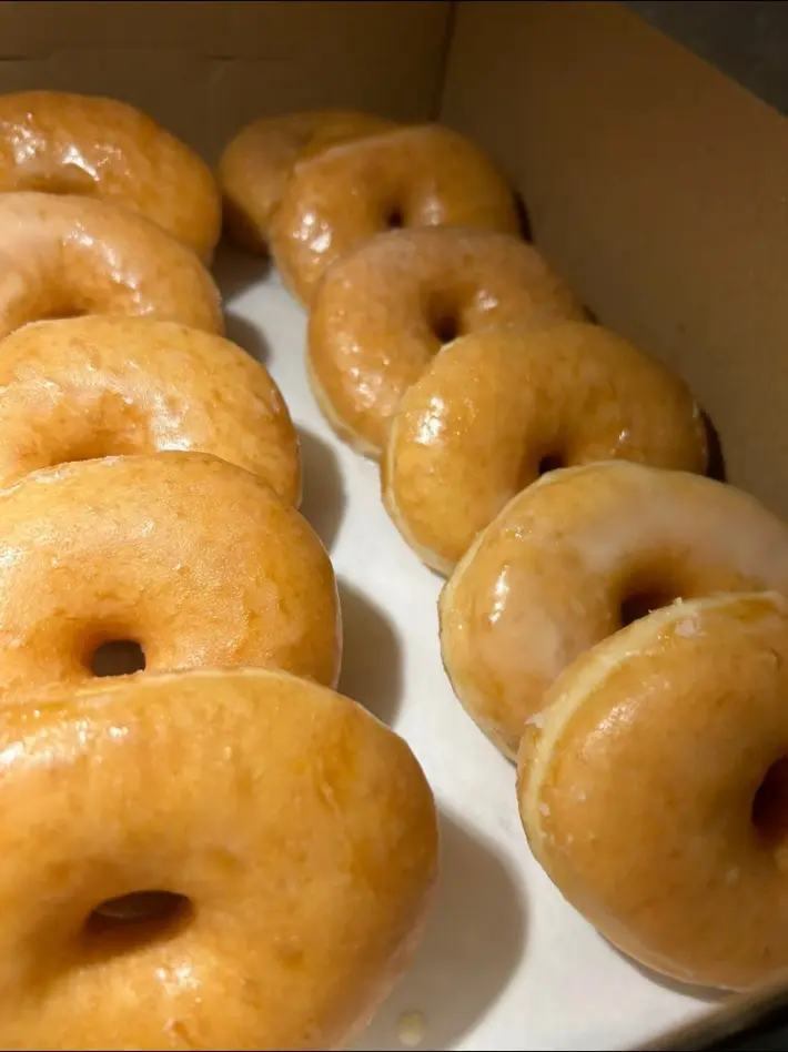 A box of freshly made original glazed plant-based donuts from Mina's Kitchen